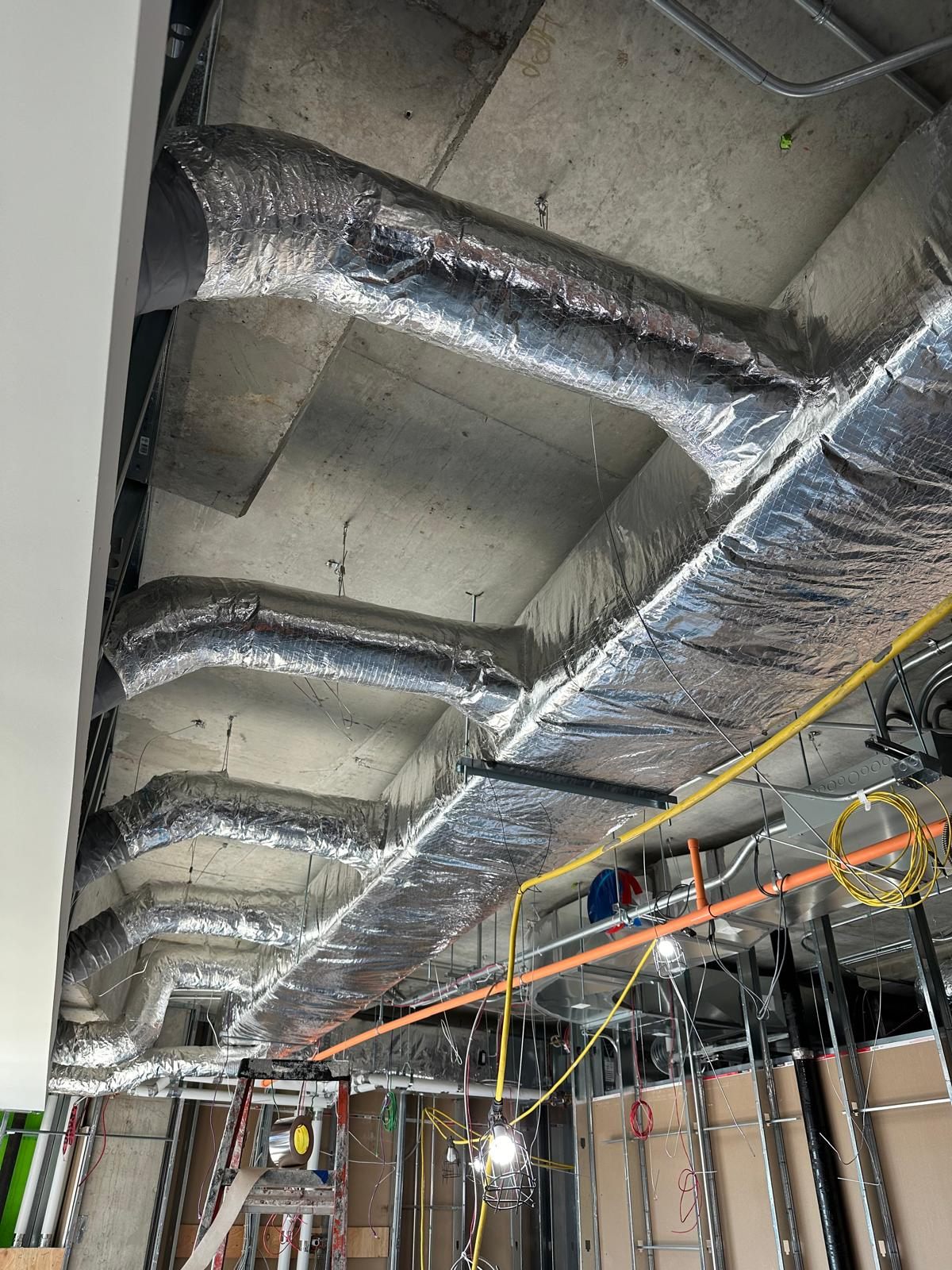 Insulated round ductwork running along ceiling